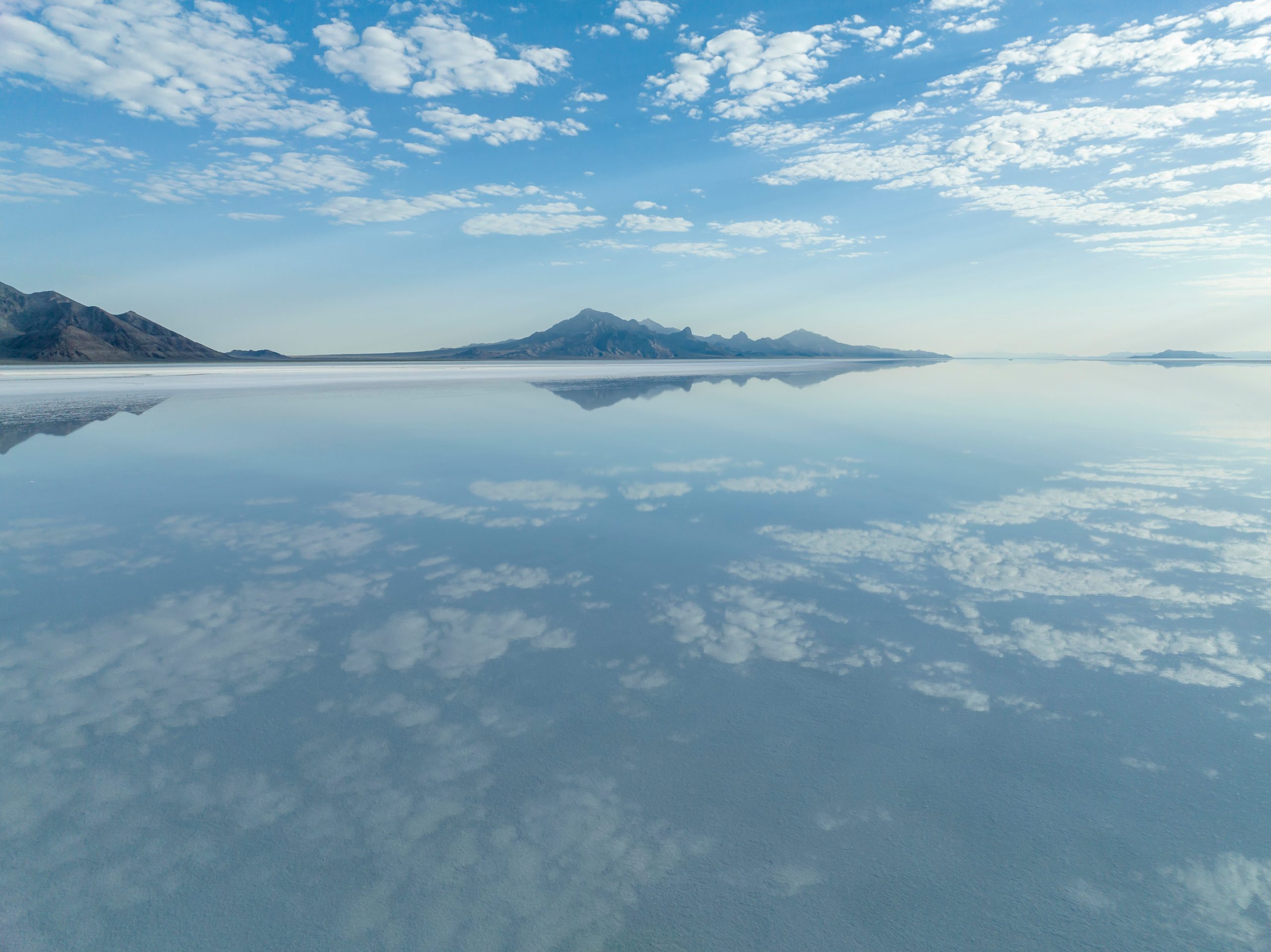 A stunning view of sky reflections at the Bonneville Salt Flats in Utah, USA, showcasing vast salt landscape.